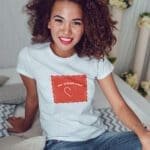 A woman wearing a My Other Half Love Unisex T-Shirt with a heart on it.