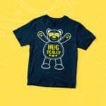 A Kids "HUG DEALER" Fine Jersey Tee, with a teddy bear on it.