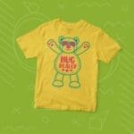A yellow Kids "HUG DEALER" Fine Jersey Tee with a teddy bear on it.