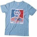 A Independence Day 4th July "BOLD BRIGHT BRAVE" Abraham Lincoln Unisex Heavy Cotton Tee featuring an image of Abraham Lincoln and an American flag, perfect for Independence Day.