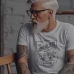 A man wearing a LUMBERJACK A Life Among The Ever Greens Unisex T-Shirt.