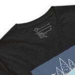 A black t-shirt with an image of mountains and a lake, embodying THE SPIRIT OF FREEDOM ALASKA.