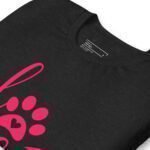 A pink paw print is printed on the front of a black Love My Dog unisex heavy cotton t-shirt, perfect for dog lovers who want to showcase their love for their furry friend.