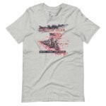 American Dream | Guns, Bikes & MAGA | Unisex t-shirt in gray showcases a graphic of a motorcycle rider holding an American flag, with 'AMERICAN DREAM' above and 'BORN, RAISED, AND MADE' below.