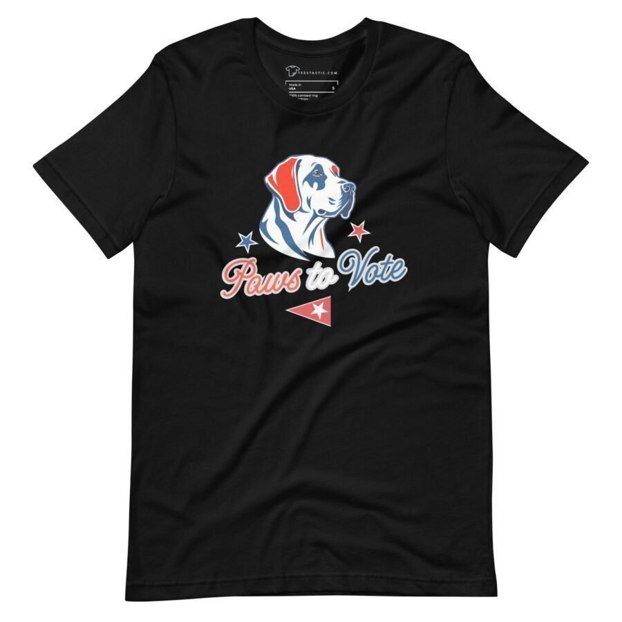 Product Description: Unisex T-shirt in black, showcasing a dog’s head graphic surrounded by stars with the text "Paws to Vote" on the front. Ideal for expressing your support in Elections 2024.