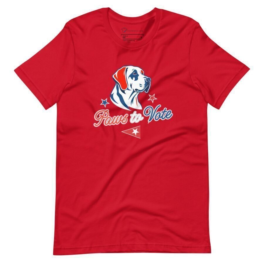 Unisex t-shirt in red, adorned with a dog graphic and the slogan "Paws to Vote", complemented by stars, a small flag, and a tribute to Elections 2024.