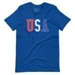 The USA | Elections 2024 | Unisex t-shirt features a blue design with the letters "USA" on the front, presenting the "U" in red, "S" in white, and "A" in blue—an ideal way to demonstrate your support for Elections 2024.