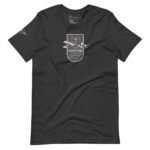 A dark gray unisex T-shirt named "Pioneer | Airline Jet 707 | Retired Aviator" features a graphic design with an aviator badge and a small airplane on the front. Additionally, it has a smaller emblem on one sleeve, making it perfect for any aviation pioneer.