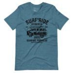 Blue unisex heavy cotton tee named "Surf & Ride | Surfing Paradise" featuring the text "Surf Ride," an image of a vintage van with surfboards on top, and additional text like "Enjoy the Ride," and "Surfing Paradise," along with other decorative elements.