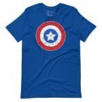 The "Star and Stripes | Red Captain America | Unisex T-shirt" features a blue fabric decorated with a distressed graphic of a circular Captain America shield, displaying a white star on a blue field, encircled by red and white rings.