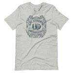 Unisex T-shirt in gray featuring "BE STRONG AND COURAGEOUS" in a decorative font, elegantly highlighting the "Joshua 1:9" verse below.