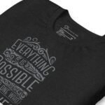 Close-up of the Unisex t-shirt in black, showcasing elegant gray text that reads, "Everything is possible to one who believes.